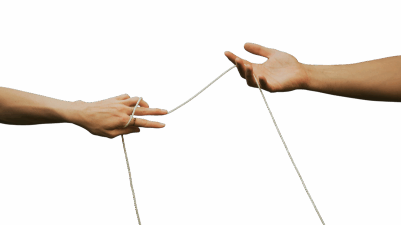 Ein Paar sitzt in einem geschützten, entspannten Raum. Sie halten Händchen und schauen einander zugewandt, während ein Workshop-Leiter im Hintergrund erklärt. Die Atmosphäre wirkt offen, vertrauensvoll und achtsam – passend zum Thema Sexualität in Beziehung.